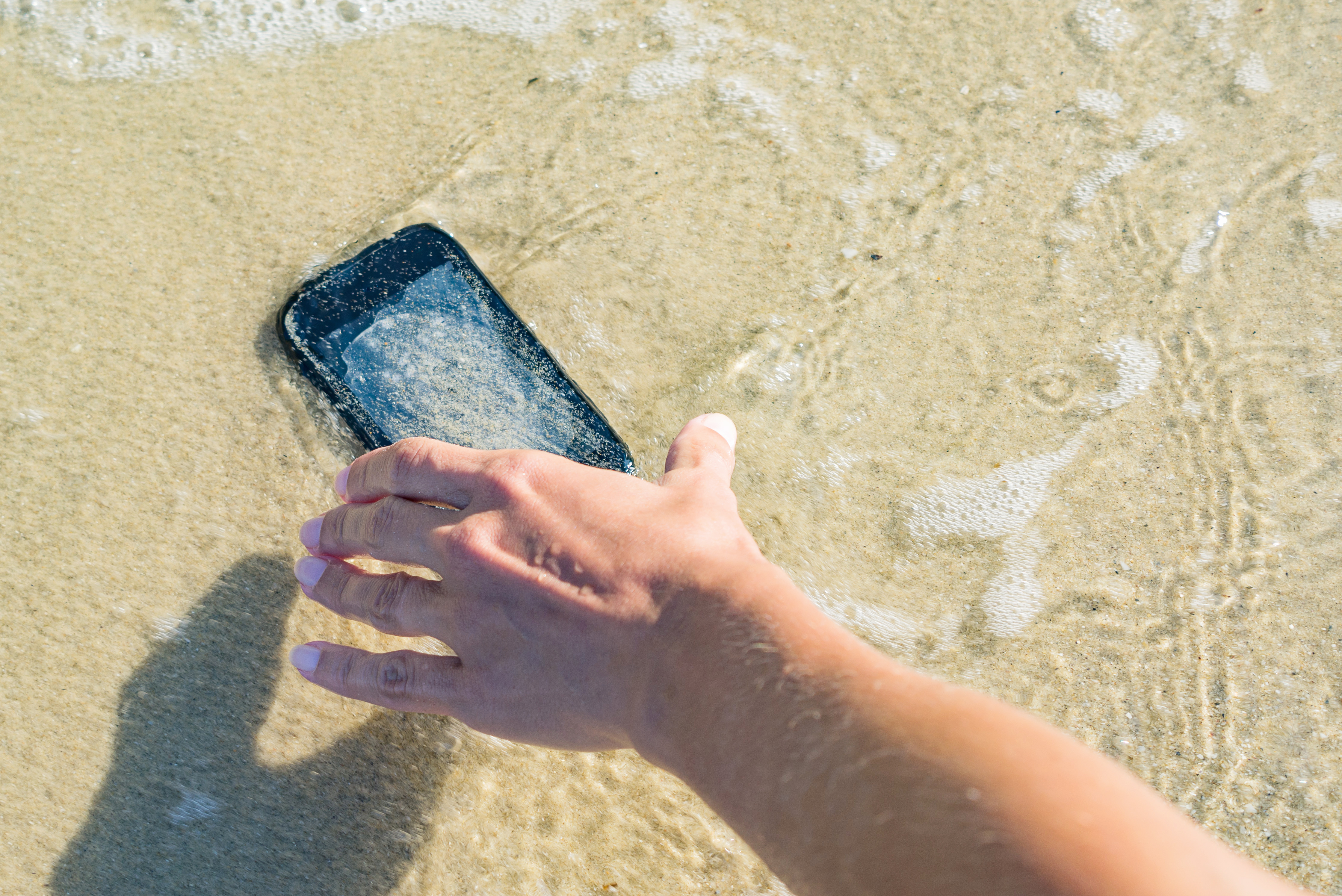 móvil mojado en el mar